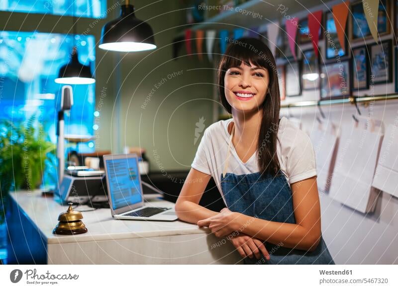 Porträt einer glücklichen Frau mit Laptop in einem Geschäft Glück glücklich sein glücklichsein Notebook Laptops Notebooks Portrait Porträts Portraits Shop Laden