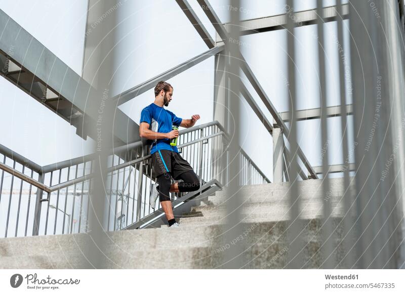 Mann auf der Treppe, der eine Pause vom Laufen macht Treppenaufgang Männer männlich Erwachsener erwachsen Mensch Menschen Leute People Personen ausruhen Rast