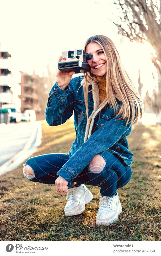 Porträt einer lächelnden jungen Frau mit Sofortbildkamera Polaroid-Kamera weiblich Frauen Portrait Porträts Portraits benutzen benützen Erwachsener erwachsen