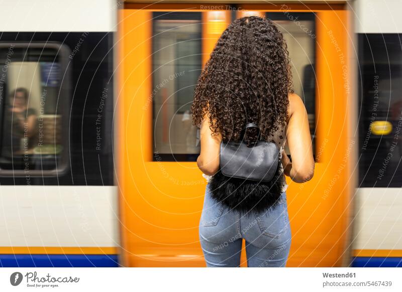 UK, London, Rückansicht einer jungen Frau, die am Bahnsteig einer U-Bahn-Station wartet Ubahn U-Bahnen Untergrundbahnen Ubahnen Underground Subway warten