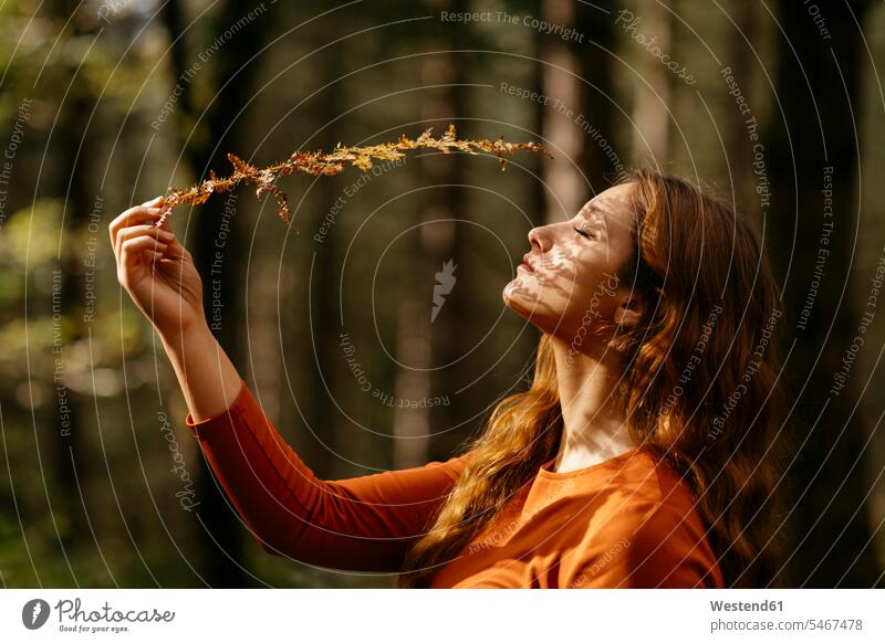 Nahaufnahme einer schönen Frau mit geschlossenen Augen, die eine Pflanze im Wald hält Farbaufnahme Farbe Farbfoto Farbphoto Spanien Freizeitbeschäftigung Muße