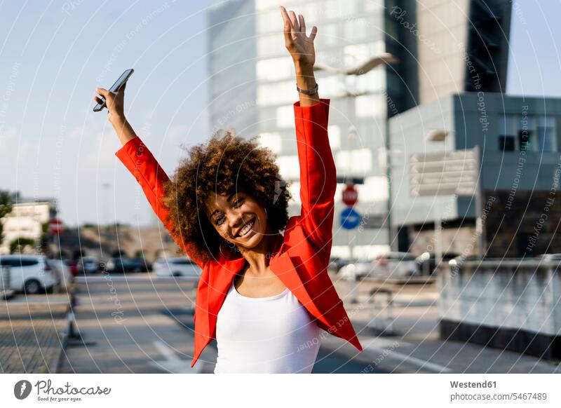 Porträt einer glücklichen jungen Frau mit Smartphone in modischer roter Anzugsjacke Telekommunikation Handies Handys Mobiltelefon Mobiltelefone entspannen