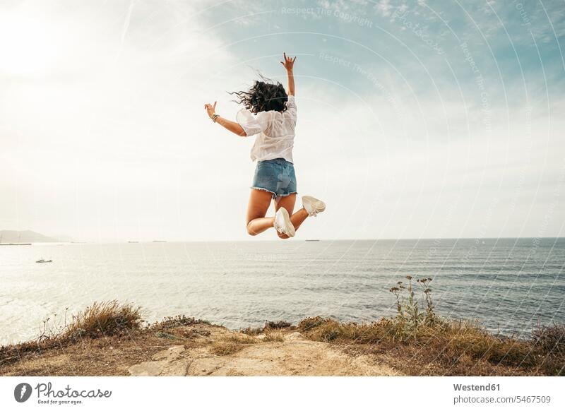 Rückansicht einer jungen Frau, die auf einen Aussichtspunkt springt, Getxo, Spanien abstürzen hinfallen stuerzen Sturz sommerlich Sommerzeit weiss weiße weißer