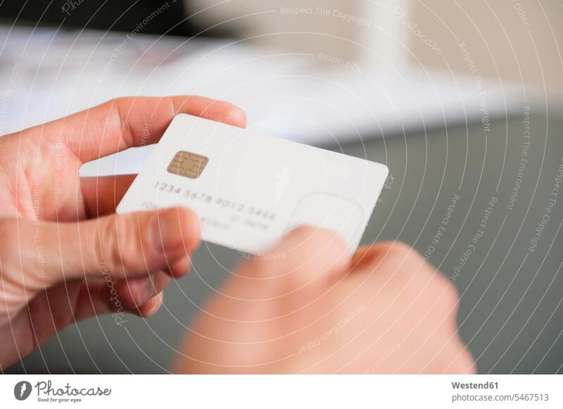 Hände eines mittleren erwachsenen Mannes mit leerer weißer Kreditkarte Farbaufnahme Farbe Farbfoto Farbphoto Deutschland Innenaufnahme Innenaufnahmen innen