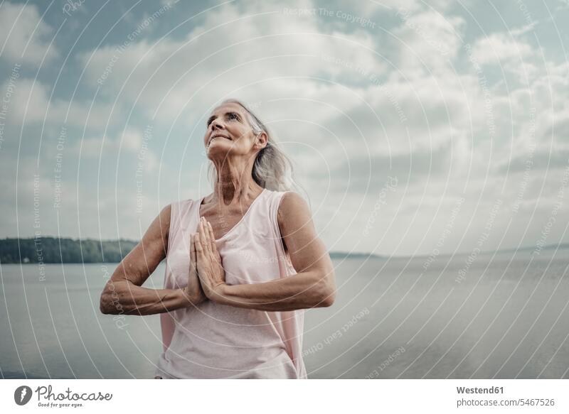 Ältere Frau meditiert am Meer Leute Menschen People Person Personen Europäisch Kaukasier kaukasisch 1 Ein ein Mensch eine nur eine Person single erwachsen