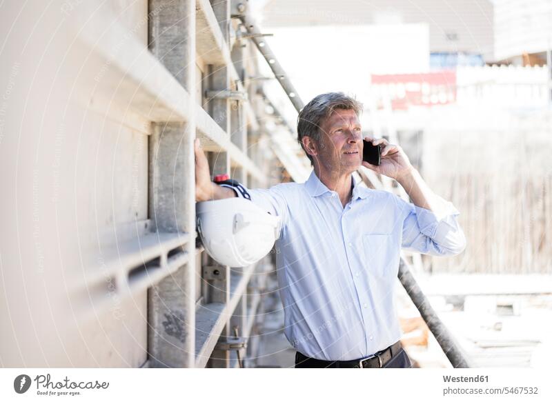 Mann am Handy auf der Baustelle Baustellen telefonieren anrufen Anruf telephonieren Mobiltelefon Handies Handys Mobiltelefone Männer männlich Konstruktion