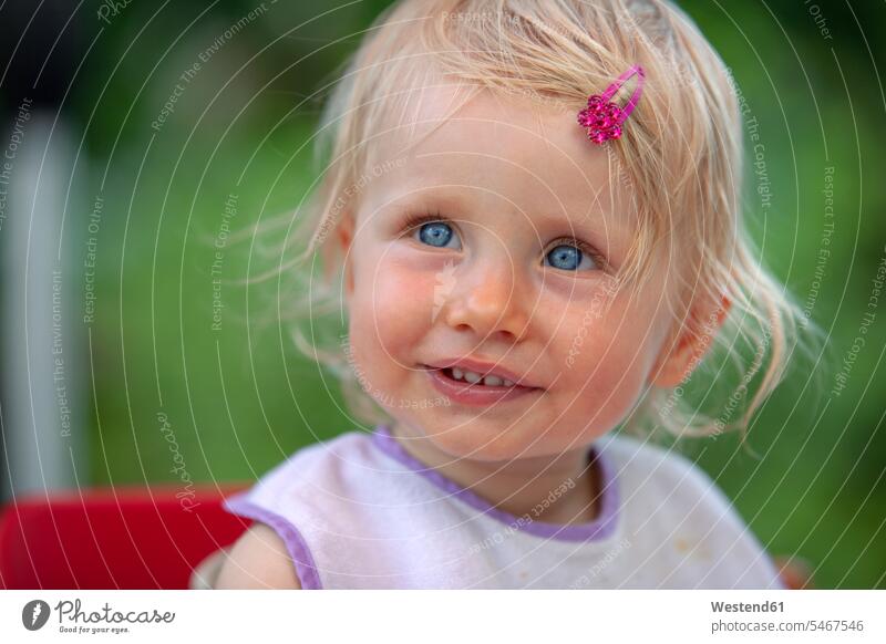 Porträt eines blonden kleinen Mädchens mit Lätzchen und rosa Haipin lächeln Haarklammer Haarspange Haarnadel Natur Magenta weiblich eine Person single 1