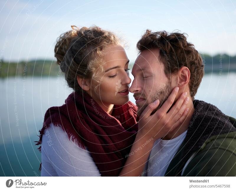 Romantioc-Paar küsst sich am See Kuss Küsse Jahreszeiten Frühjahr Lenz Glück glücklich sein glücklichsein gefühlvoll Emotionen Empfindung Empfindungen fühlen
