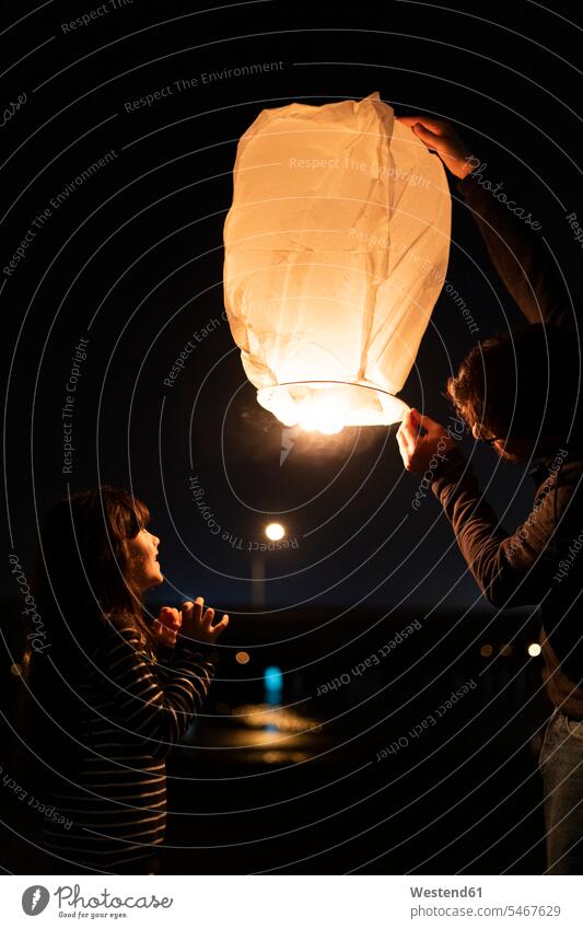 Vater und Tochter bereiten eine Himmelslaterne bei Nacht vor fasziniert Faszination Nachthimmel Quality Time glücklich Glück glücklich sein glücklichsein