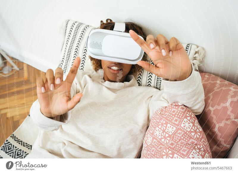 Junge Frau zu Hause mit VR-Brille Leute Menschen People Person Personen Afrikanisch Afrikanische Abstammung dunkelhäutig Farbige Farbiger Schwarze 1 Ein