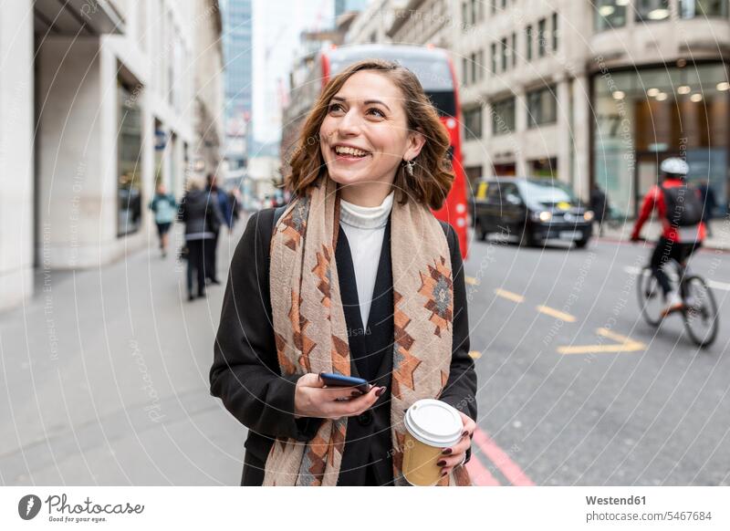 Porträt einer glücklichen Frau in der Stadt, London, UK Jacken Telekommunikation telefonieren Handies Handys Mobiltelefon Mobiltelefone freuen Frohsinn