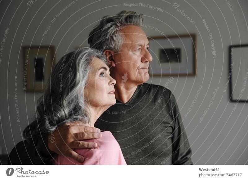 Porträt eines älteren Ehepaares zu Hause Rahmen Bilder Bildnis entspannen relaxen Arm umlegen Umarmung Umarmungen entspanntheit relaxt gefühlvoll Emotionen