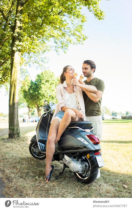 Glückliches Paar mit Motorroller im Sommer Eis essen Roller Piaggio glücklich glücklich sein glücklichsein Pärchen Paare Partnerschaft Sommerzeit sommerlich