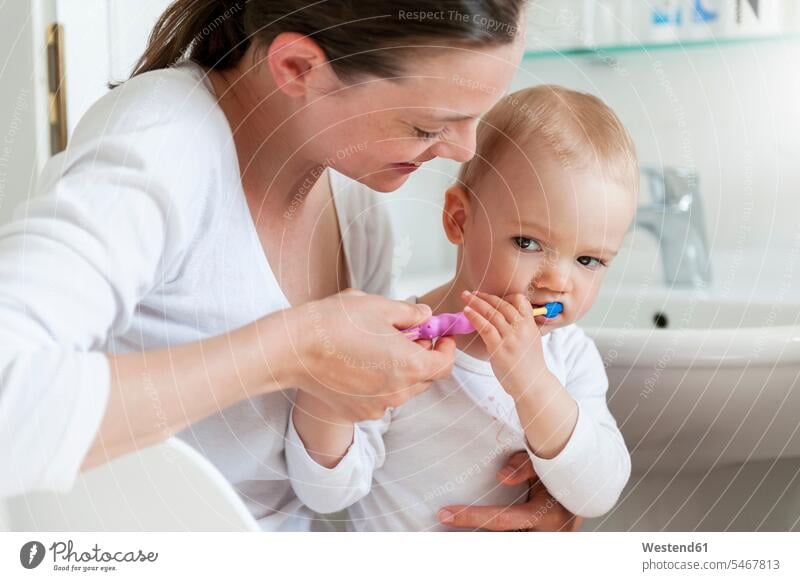 Mutter putzt Babyzähne im Badezimmer Mami Mutti Mütter Mama putzen reinigen Zahn Zähne Babies Babys Säuglinge Kind Kinder Zuhause zu Hause daheim Eltern Familie