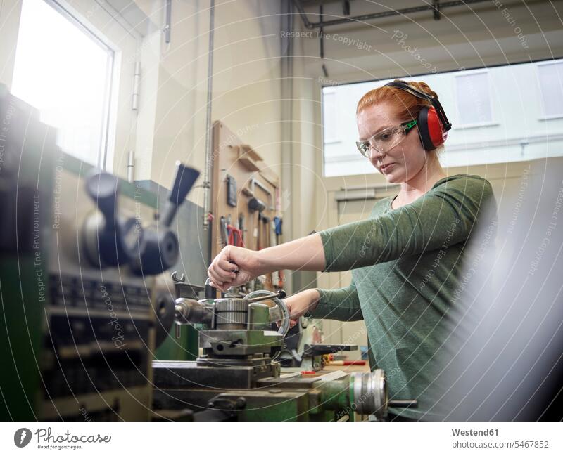 Frau, die an einer Drehbank arbeitet Job Berufe Berufstätigkeit Beschäftigung Jobs Arbeiter Techniken Technologie Techniker Metalle metallisch stehend steht