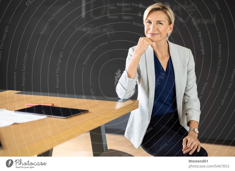 Porträt einer selbstbewussten blonden Geschäftsfrau im Konferenzraum mit Tafel Job Berufe Berufstätigkeit Beschäftigung Jobs geschäftlich Geschäftsleben