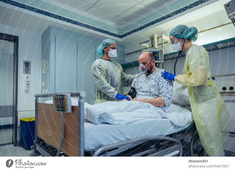 Ärzte, die einen Patienten auf der Notfallstation eines Krankenhauses künstlich beatmen Arbeitskollege Arbeitskollegen Kollege Gesundheit Gesundheitswesen