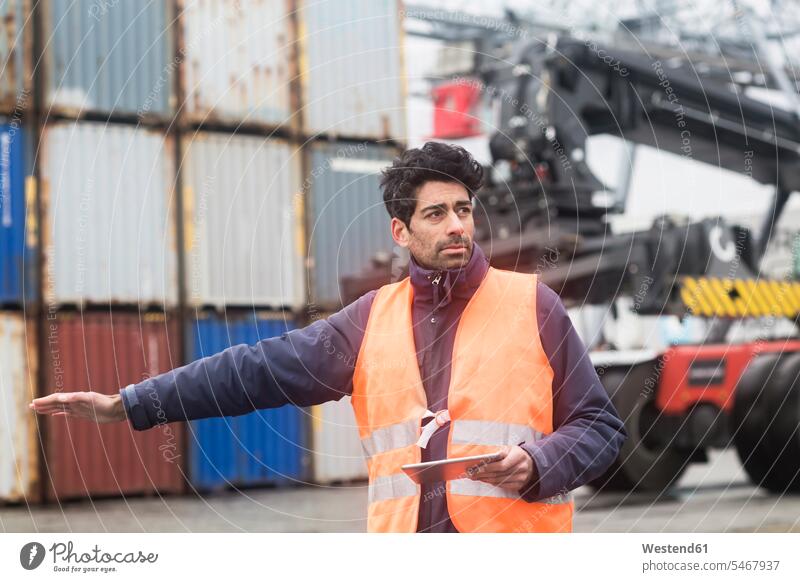 Mann mit Tablette in reflektierender Weste im Containerhafen Containerhaefen Containerhäfen Leuchtweste Warnwesten high-visibility jacket Leuchtwesten