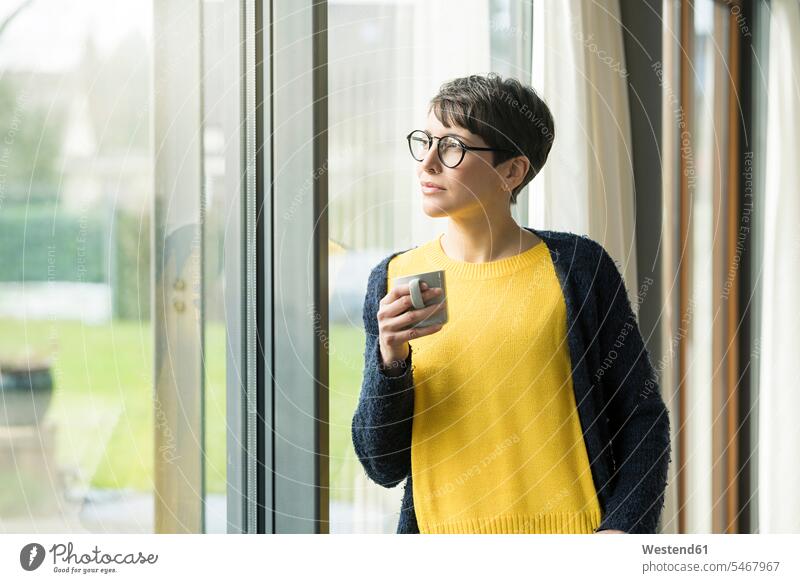Porträt einer Frau mit einer Tasse Kaffee, die aus dem Fenster schaut Kaffeetasse Kaffeetassen Portrait Porträts Portraits weiblich Frauen schauen sehend