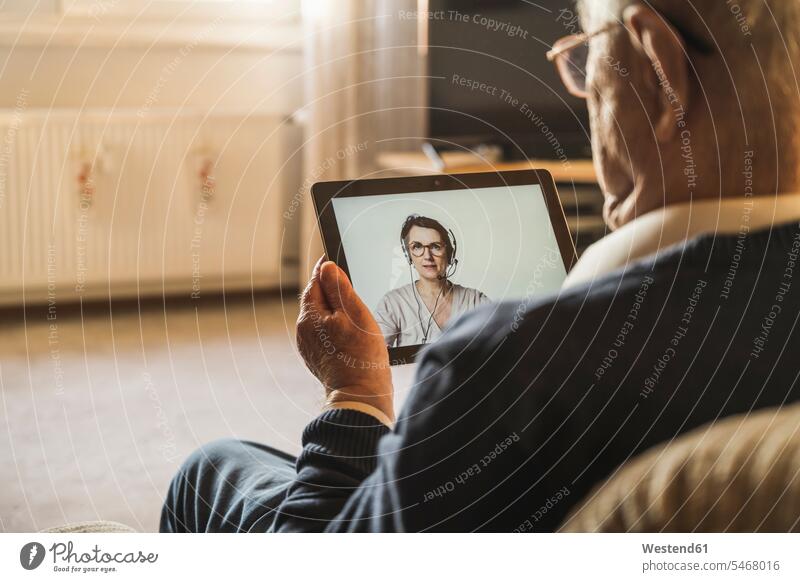 Älterer männlicher Patient, der sich von einer Allgemeinmedizinerin per Videoanruf über ein digitales Tablet beraten lässt Farbaufnahme Farbe Farbfoto Farbphoto