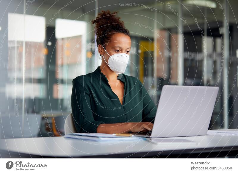 Porträt einer Geschäftsfrau mit Schutzmaske bei der Arbeit am Laptop am Schalter Job Berufe Berufstätigkeit Beschäftigung Jobs geschäftlich Geschäftsleben
