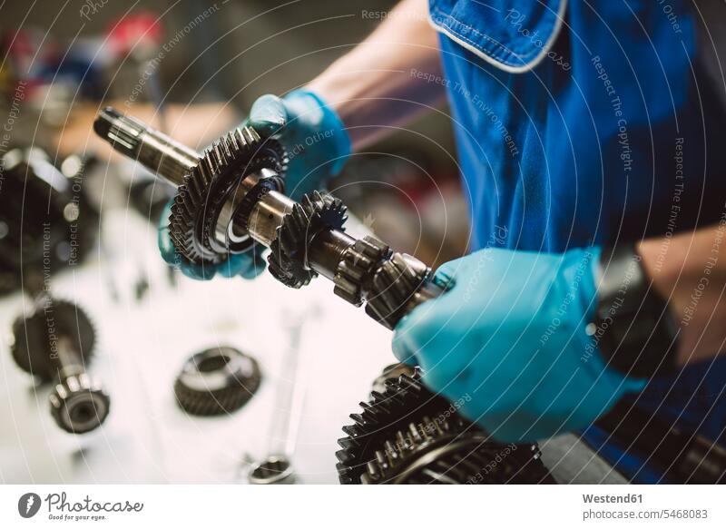 Nahaufnahme eines Mechanikers, der in einer Werkstatt an den Teilen eines Autos arbeitet Werkstätte Werkstaette Werkstaetten Werkstätten Monteur reparieren