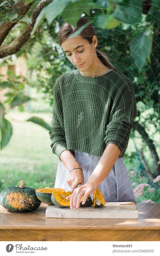 Junge Frau schneidet Kürbis für die Zubereitung von Gnocchis zubereiten kochen Essen zubereiten schneiden weiblich Frauen Kürbisse Kuerbis Kuerbisse Erwachsener