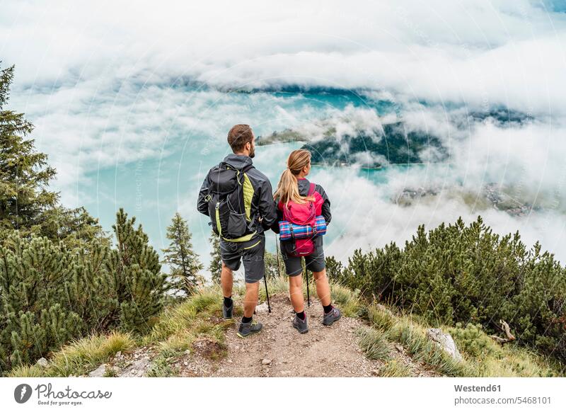 Junges Paar auf einer Wanderung in den Bergen mit Blick auf die Aussicht, Herzogstand, Bayern, Deutschland Leute Menschen People Person Personen Europäisch
