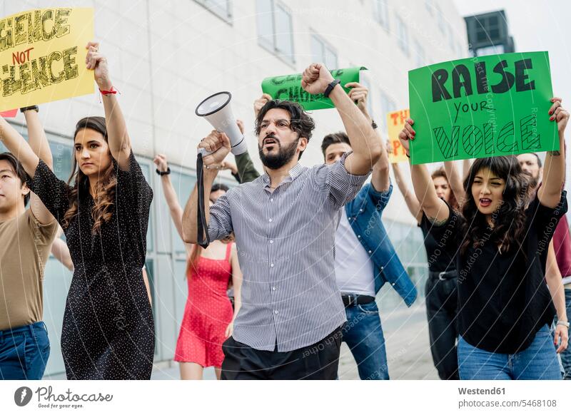 Multiethnische Aktivisten protestieren in der Stadt Farbaufnahme Farbe Farbfoto Farbphoto Freizeitkleidung Freizeitbekleidung casual Außenaufnahme außen draußen