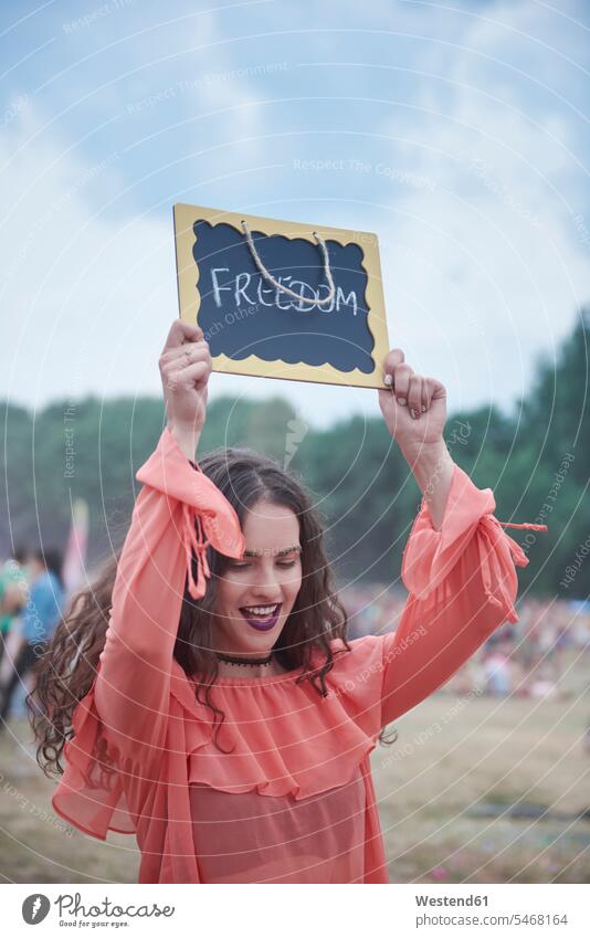 Frau hält Schild beim Musikfestival, Freiheit lächeln Schilder Zeichen hochhalten heben hochheben frei Musiktage Musikfestspiele glücklich Glück glücklich sein