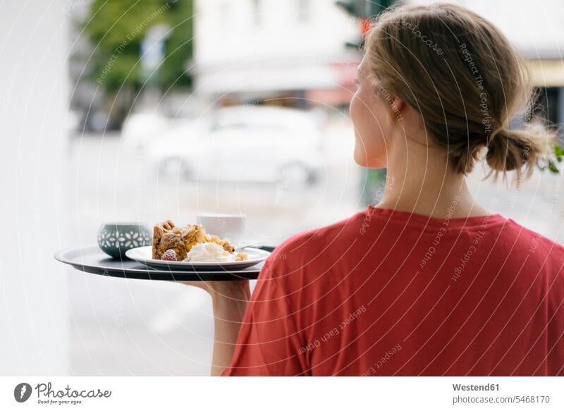 Rückansicht einer jungen Frau, die Kaffee und Kuchen in einem Café serviert servieren Cafe Kaffeehaus Bistro Cafes Cafés Kaffeehäuser weiblich Frauen Getränk