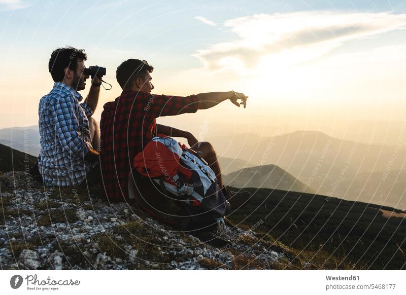 Italien, Monte Nerone, zwei Wanderer auf dem Gipfel eines Berges genießen die Aussicht bei Sonnenuntergang Ausblick Ansicht Überblick Gebirge Berglandschaft