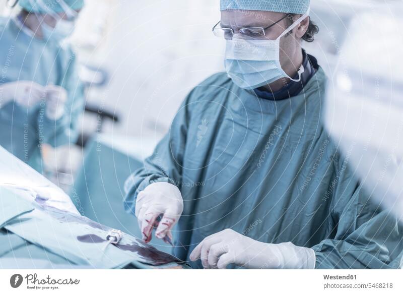Neuroradiologe im Kittel während einer Operation Arzt Doktoren Ärzte Krankenhaus Kliniken Krankenhäuser Krankenhaeuser Operationskittel OP Operationen operieren