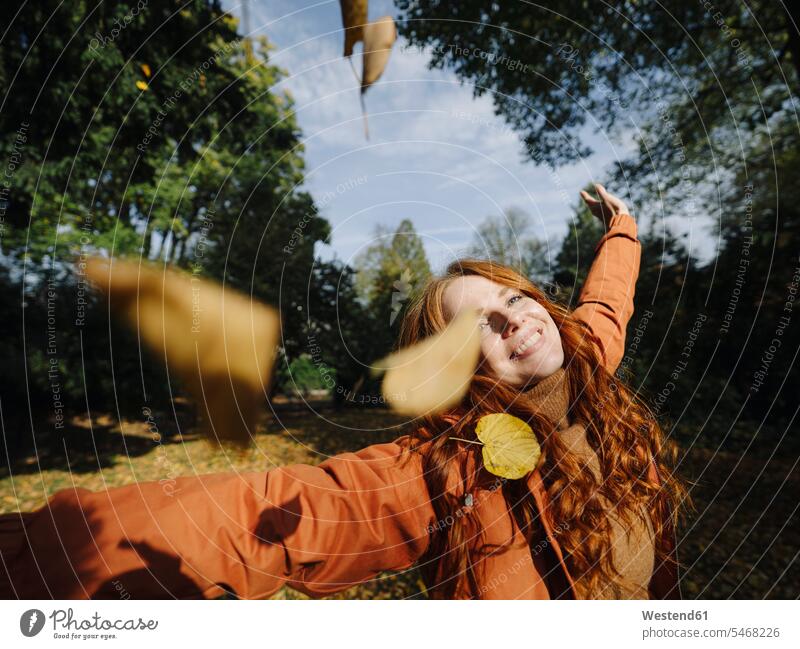 Glückliche rothaarige Frau genießt den Herbst in einem Park Leute Menschen People Person Personen Europäisch Kaukasier kaukasisch 1 Ein ein Mensch