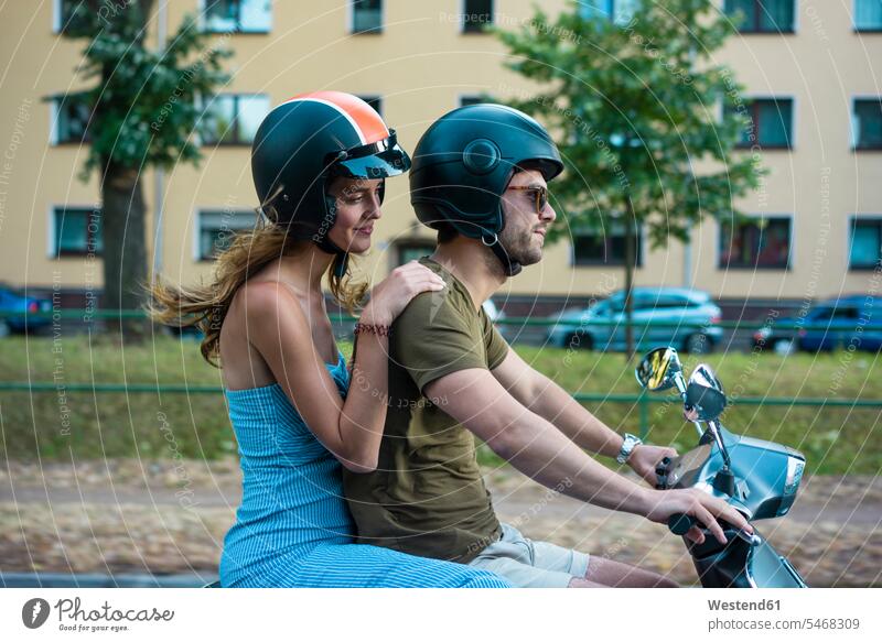 Pärchen fährt Motorroller in der Stadt Roller Piaggio fahren staedtisch städtisch Paar Paare Partnerschaft Sommer Sommerzeit sommerlich Kraftfahrzeug