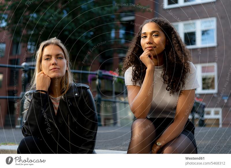 Zwei Freundinnen auf einer Städtereise in Amsterdam, Niederlande sitzen sitzend sitzt City Trip Kurztripp City Break reisen Travel verreisen Weg Reise Urban