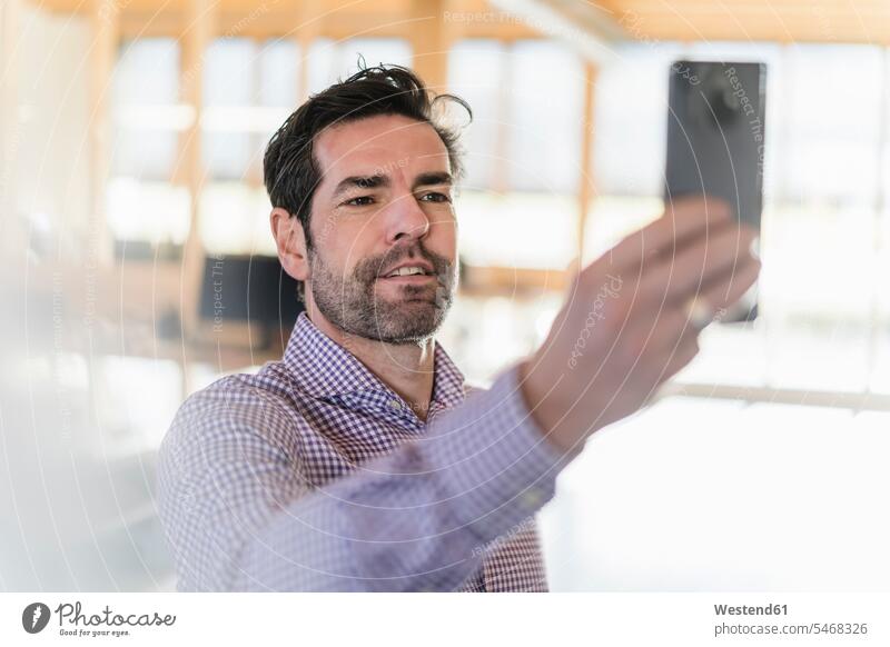Geschäftsmann macht ein Selfie in einem Großraumbüro aus Holz Job Berufe Berufstätigkeit Beschäftigung Jobs geschäftlich Geschäftsleben Geschäftswelt
