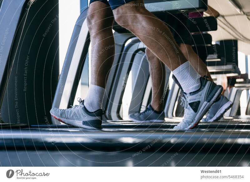 Beine von Athleten, die auf Laufbändern im Fitnessstudio laufen Farbaufnahme Farbe Farbfoto Farbphoto Innenaufnahme Innenaufnahmen innen drinnen Fitnessstudios