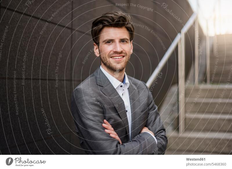 Porträt eines lächelnden Geschäftsmannes auf einer Treppe Businessmann Businessmänner Geschäftsmänner Zuversicht Zuversichtlich Selbstvertrauen selbstbewusst