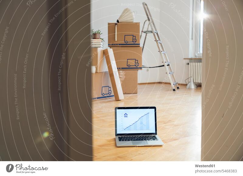 Steigende Liniengrafik auf Laptop-Bildschirm vor Pappkartons in einem leeren Raum in einem neuen Heim Boeden Böden Holzboeden Holzböden Technik Technologien