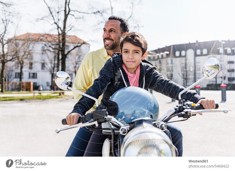 Vater und Sohn auf einem Motorrad Motorräder glücklich Glück glücklich sein glücklichsein Papas Väter Vati Vatis Papis Söhne Kraftfahrzeug Verkehrsmittel KFZ