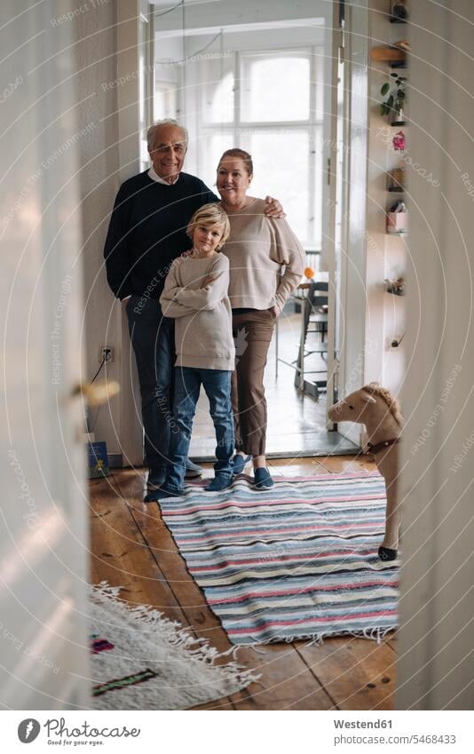 Porträt von glücklichen Großeltern mit Enkel zu Hause Generation Arm umlegen Umarmung Umarmungen freuen Glück glücklich sein glücklichsein innig nah zufrieden
