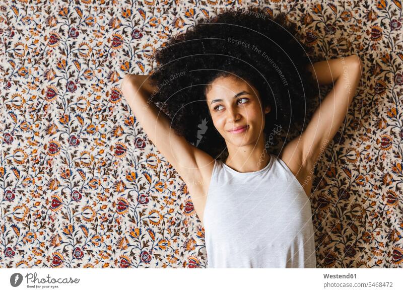 Porträt einer glücklichen jungen Frau auf Teppich liegend Leute Menschen People Person Personen Nordafrikanisch 1 Ein ein Mensch nur eine Person single