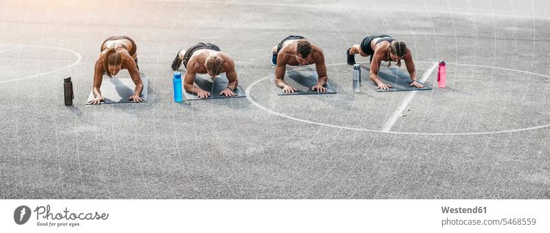 Sportliches Team beim Training, Planke Unterarmstütz Planks Sportler Schiefe Ebene Workout Betonboden Aktivität Aktivitaet aktiv Arm Arme Sportplatz