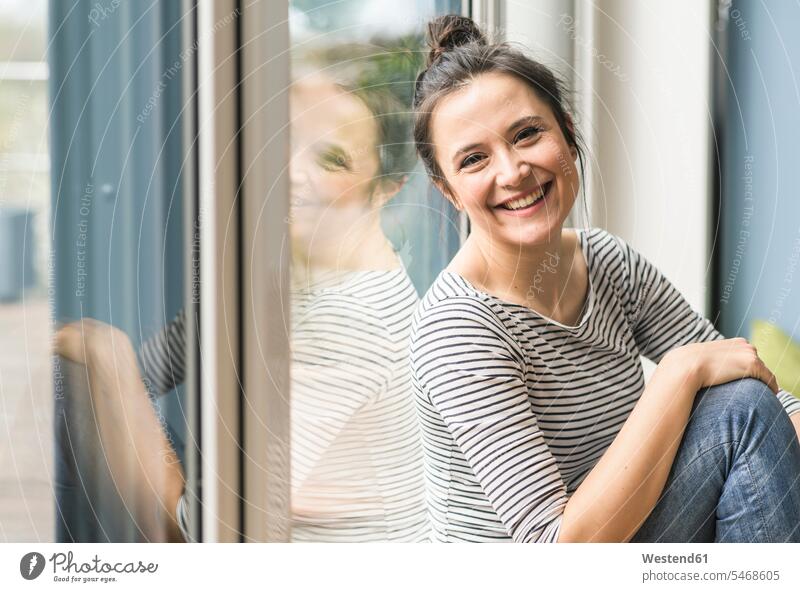 Porträt der glücklichen Frau sitzt am Fenster zu Hause Zuhause daheim Portrait Porträts Portraits sitzen sitzend weiblich Frauen Glück glücklich sein