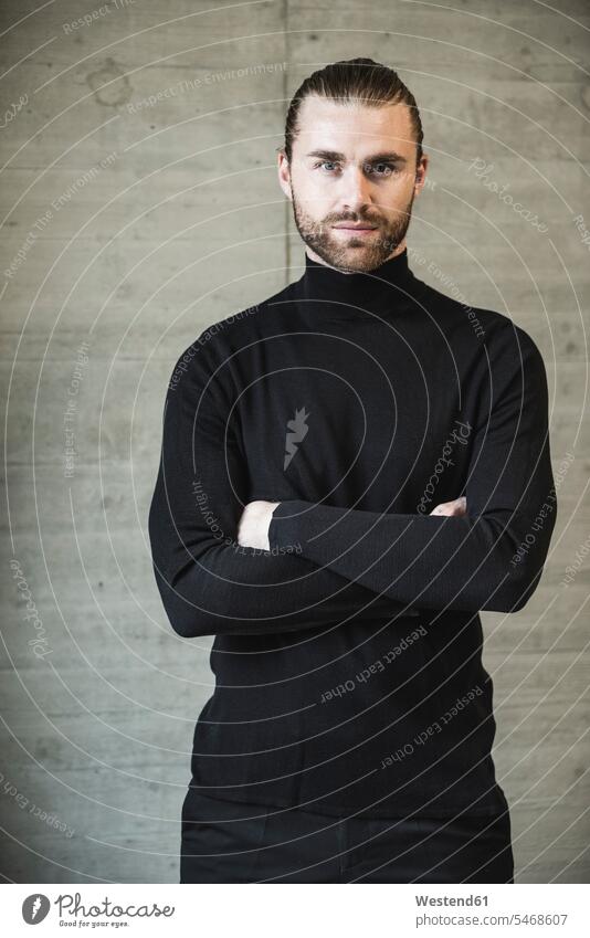 Porträt eines selbstbewussten jungen Mannes mit schwarzem Rollkragenpullover Portrait Porträts Portraits Pullover schwarzer schwarzen schwarzes stehen stehend