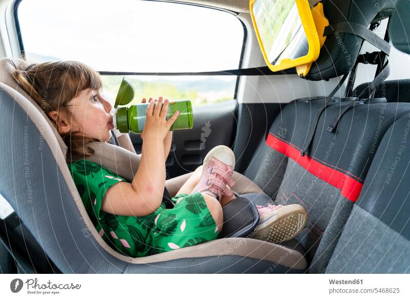 Kleinkind, das auf einem Autositz mit einem Spiegel sitzt, trinkt Wasser Leute Menschen People Person Personen Europäisch Kaukasier kaukasisch 1 Ein ein Mensch
