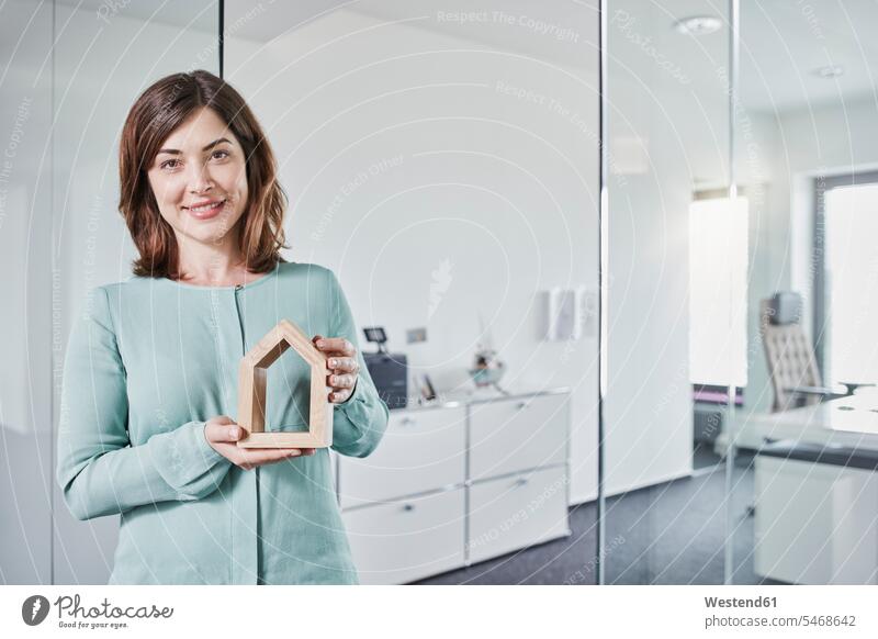 Porträt einer lächelnden jungen Geschäftsfrau mit Architekturmodell im Amt Portrait Porträts Portraits Büro Office Büros Geschäftsfrauen Businesswomen