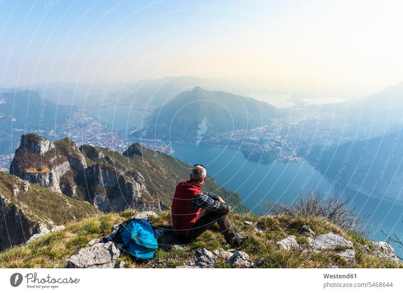 Rückansicht eines auf dem Berggipfel sitzenden Wanderers, Orobie Alps, Lecco, Italien Leute Menschen People Person Personen Europäisch Kaukasier kaukasisch 1