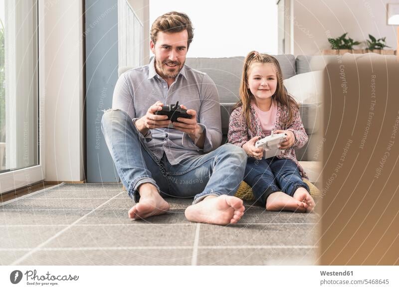 Junger Mann und kleines Mädchen spielen Computerspiel mit Spielkonsole Wettbewerb Wettkampf Konkurrenz Alleinerziehend Ein Elternteil Handsteuerung